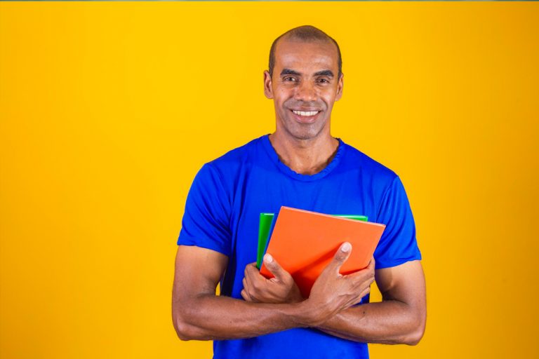 homem em pé segurando material de estudo